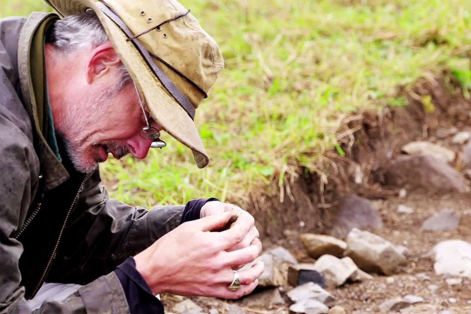 SLU archaeologist Thomas Finan, Ph.D., examines a shard at an excavation he, his students and Irish colleagues are conducting at a medieval Gaelic royal settlement.