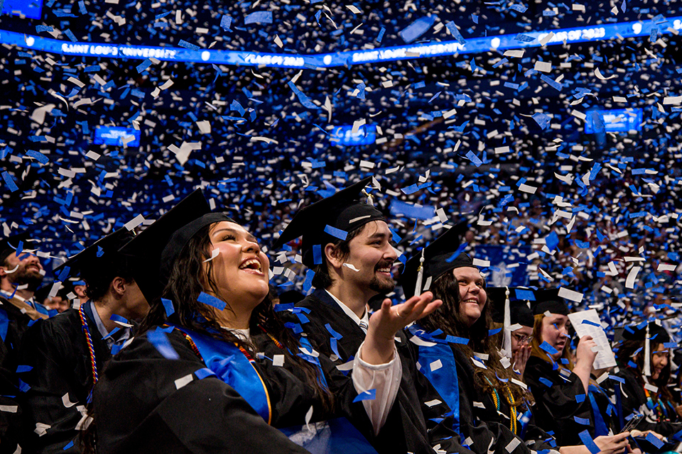 Confetti falls on graduates sitting on the floor of Chaifetz Arena during the 2023 Midyear Commencement