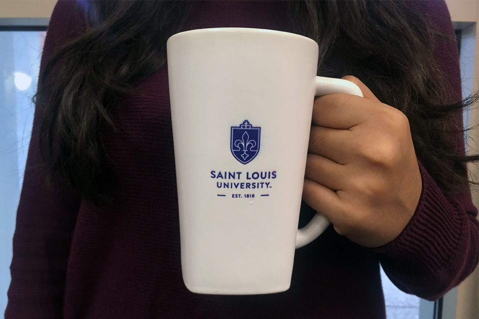 SLU coffee cup in hand