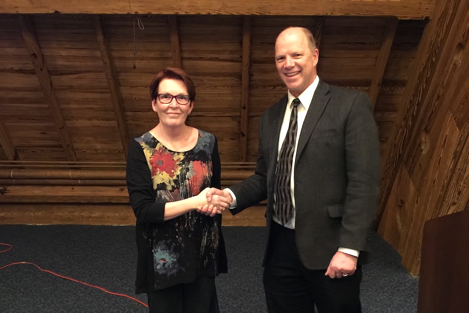 Marla Berg-Weger, left, shakes, Mario Schootman's hand at the College's annual research award reception.