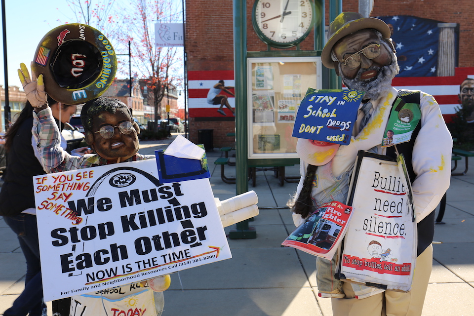 Two statues in North St. Louis have been decorated with signs reading "Stay in School" and "We Must Stop Killing Each Other" among others.