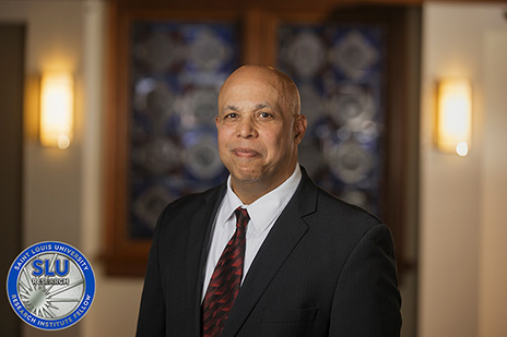 A headshot of Michael Duff, J.D., alongside the induction coin awarded to SLU Research Institute Fellows.