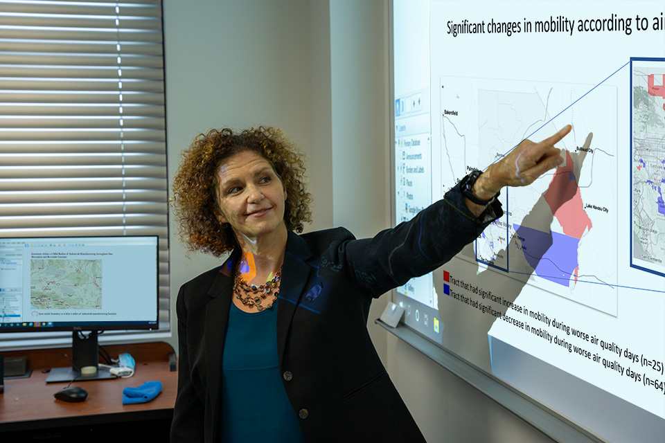 Enbal Shacham, Ph.D., points to a screen showing her latest research results on air quality and pediatric asthma.