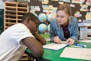 A SLU School of Education student instructs an elementary school student in a classroom during a student teaching session.