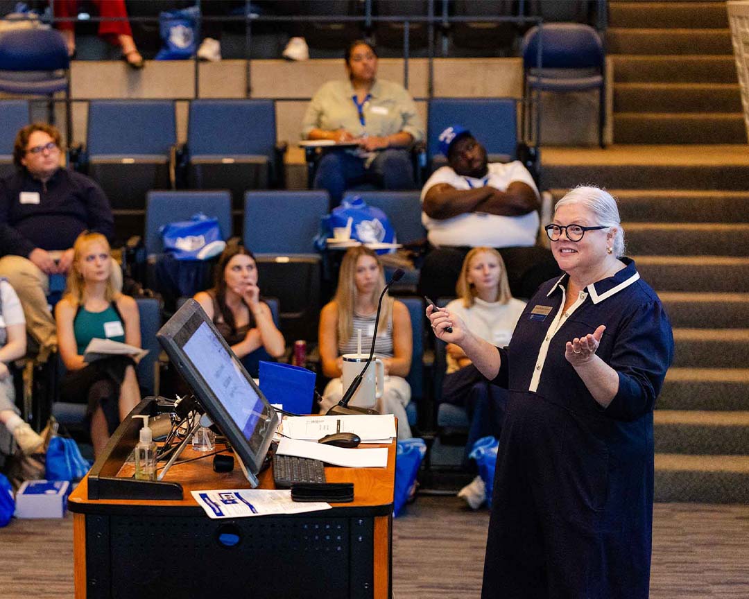 A female professor delivers a lecture to her class