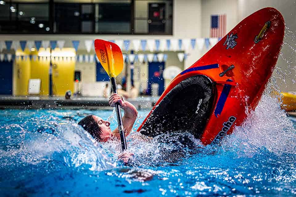 A kayaker nearly flips in their kayak while practicing in a SLU pool.